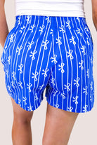 mid-rise relaxed fit boxer shorts with side pockets and an elastic waistband, designed on a bow and stripe pattern print and a solid base in blue