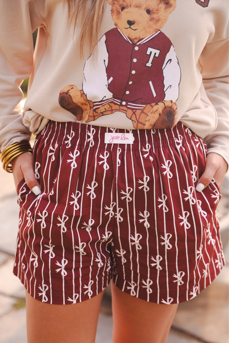 mid-rise relaxed fit boxer shorts with side pockets and an elastic waistband, designed on a bow and stripe pattern print and a solid base in maroon