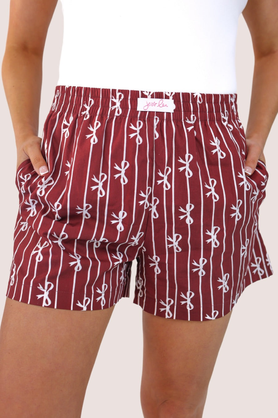 mid-rise relaxed fit boxer shorts with side pockets and an elastic waistband, designed on a bow and stripe pattern print and a solid base in maroon