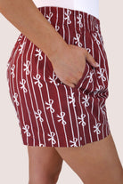 mid-rise relaxed fit boxer shorts with side pockets and an elastic waistband, designed on a bow and stripe pattern print and a solid base in maroon