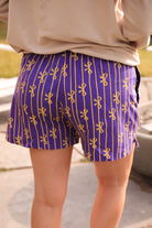 mid-rise relaxed fit boxer shorts with side pockets and an elastic waistband, designed on a bow and stripe pattern print and a solid base in purple
