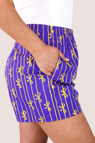 mid-rise relaxed fit boxer shorts with side pockets and an elastic waistband, designed on a bow and stripe pattern print and a solid base in purple