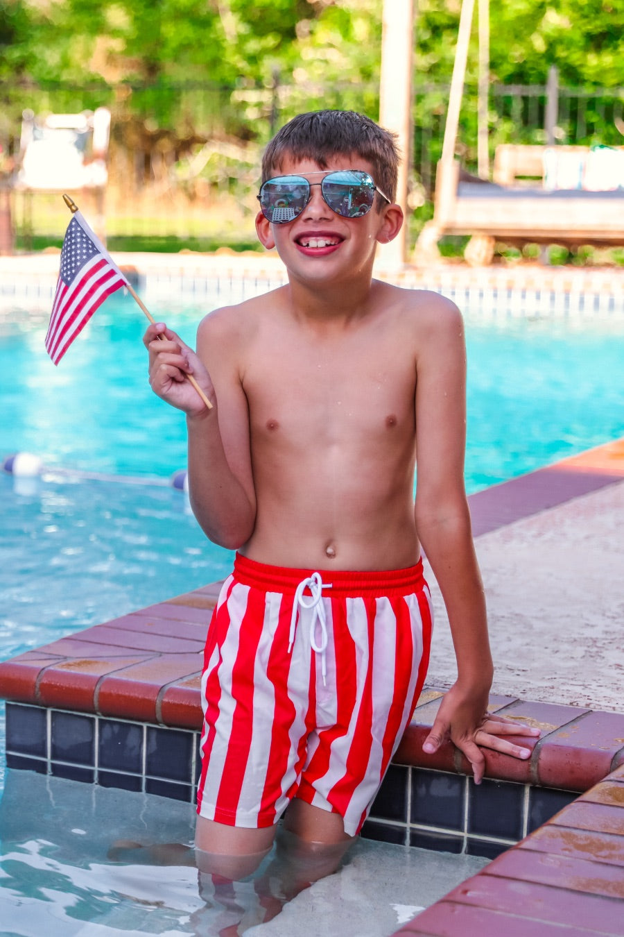 red and white vertical stripe swim trunks with an elastic waistband, drawstring tie, pockets, and built-in mesh underwear