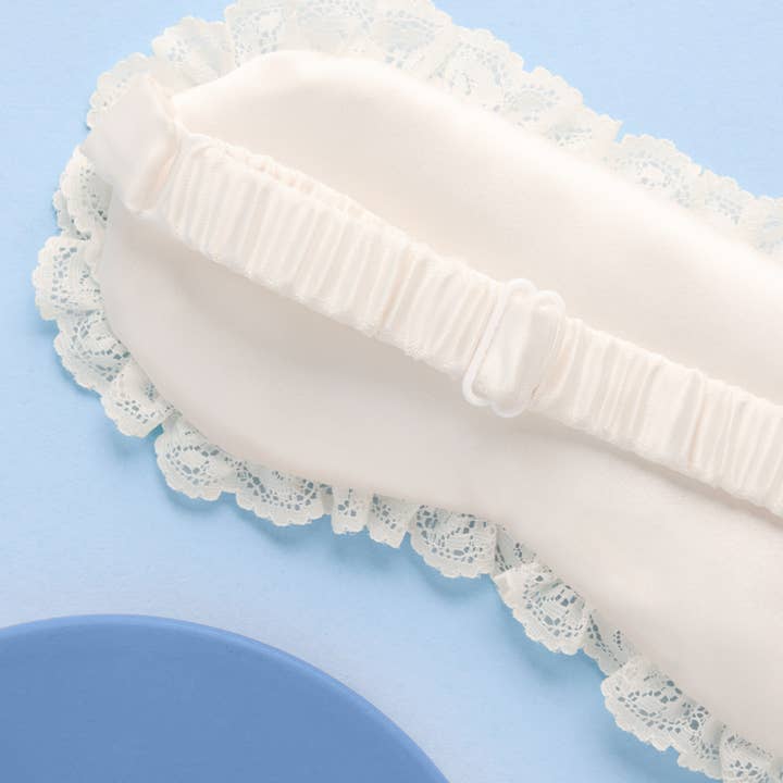 White lace-trimmed pillow on a light blue background