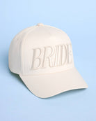 Beige cap with 'BRIDE' text on a light blue background