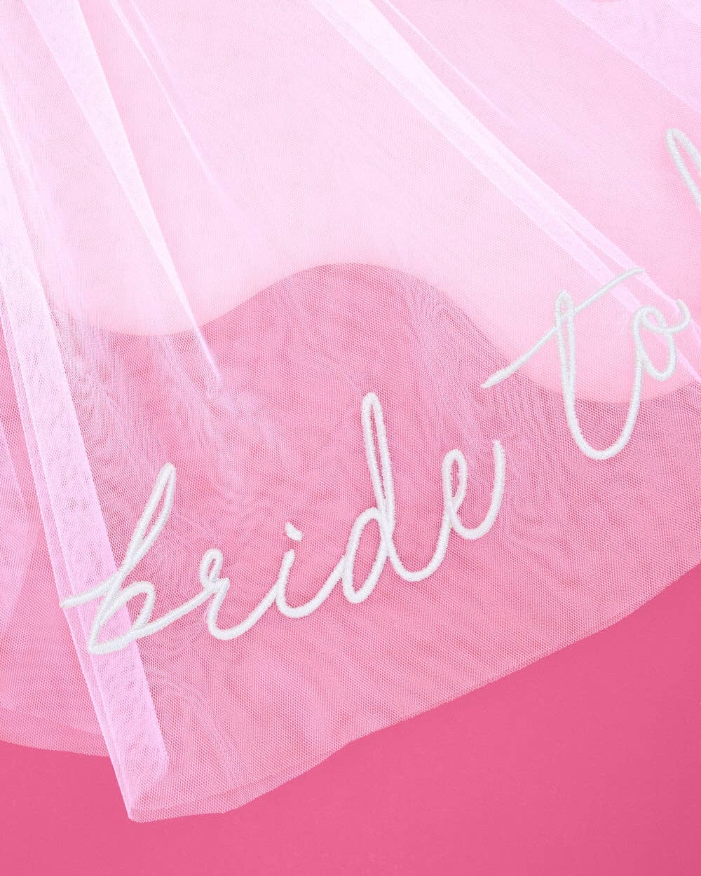 Sheer fabric with 'bride to be' text on a pink background