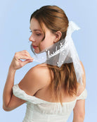 Woman wearing a white veil with 'bride to be' text against a light blue background