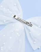 Hair bow with pearl embellishments and a hair clip on a light blue background