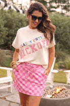 mid-rise relaxed fit everyday skort made of lightweight material with built-in cream shorts, drawstring tie with gold bead accents, an elastic band on the back, and side pockets, designed on a two-tone pink checkered pattern print fabric