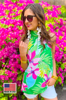 a bold green tropical floral halter with an adjustable tie-back neckline, airy draped silhouette, and lightweight woven fabric with no stretch and a MADE IN USA watermark in bottom left-hand corner
