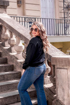 a black long-sleeve cropped sweatshirt with a crew neckline, drop-shoulder fit, rhinestone star detailing, and ribbed trim at the cuffs, hemline, and neckline