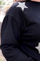 a black long-sleeve cropped sweatshirt with a crew neckline, drop-shoulder fit, rhinestone star detailing, and ribbed trim at the cuffs, hemline, and neckline