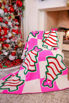 ultra-soft throw on a bold pink and white checkered background decorated with whimsical Christmas tree treats, each topped with an adorable pink bow paired with our Bow Christmas Treat Pillow