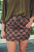 mid-rise relaxed fit everyday skort made of lightweight material with built-in cream shorts, drawstring tie with gold bead accents, an elastic band on the back, and side pockets, designed on a brown on brown pattern print fabric