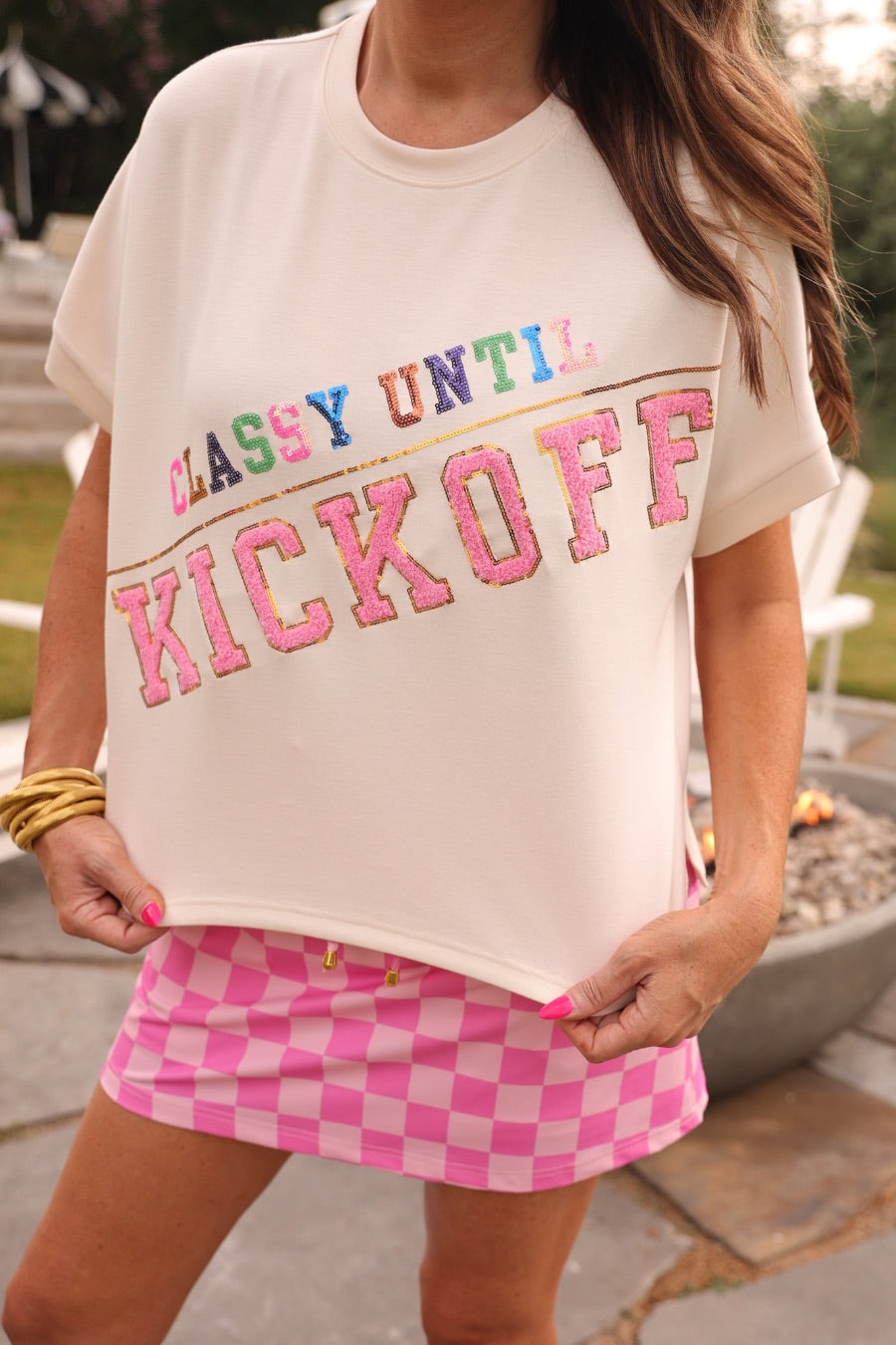 cream short-sleeve mom crop top crafted on a soft, lightweight luxe material with multicolor sequin lettering spelling out CLASSY UNTIL, accented by a gold sequin divider bar, and finished with bold pink chenille KICKOFF lettering outlined in gold sequins
