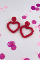 a red beaded post stud with a matching beaded open heart-shape drop and a comfort earring back in gold