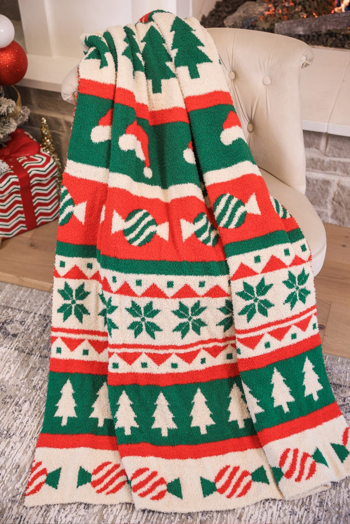 festive holiday pattern blanket of Christmas trees, Santa hats, wrapped candy, and snowflakes