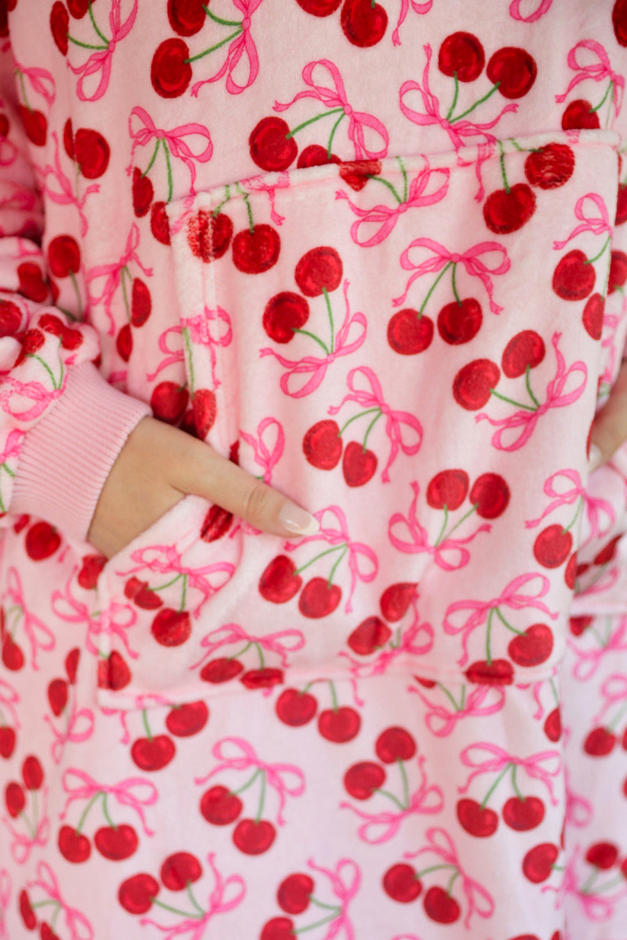 a blanket hoodie with roomy long sleeves finished with soft ribbed cuffs, a slouchy hood, drop shoulder, a kangaroo pouch on ultra plush fabric in Cherry Bomb (Pink)
