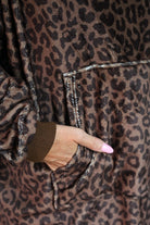 a blanket hoodie with roomy long sleeves finished with soft ribbed cuffs, a slouchy hood, drop shoulder, a kangaroo pouch on ultra plush fabric in Coco Leopard (Leopard)