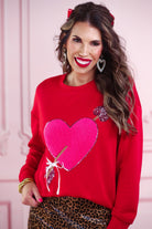 a long-sleeve pullover made from luxe material with a classic crew neckline, a relaxed drop-shoulder fit, and a statement chenille heart accented with intricate embroidery and a sequins bow-and-arrow detail