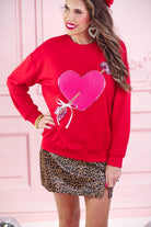 a long-sleeve pullover made from luxe material with a classic crew neckline, a relaxed drop-shoulder fit, and a statement chenille heart accented with intricate embroidery and a sequins bow-and-arrow detail