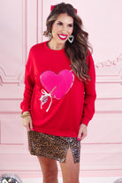 a long-sleeve pullover made from luxe material with a classic crew neckline, a relaxed drop-shoulder fit, and a statement chenille heart accented with intricate embroidery and a sequins bow-and-arrow detail