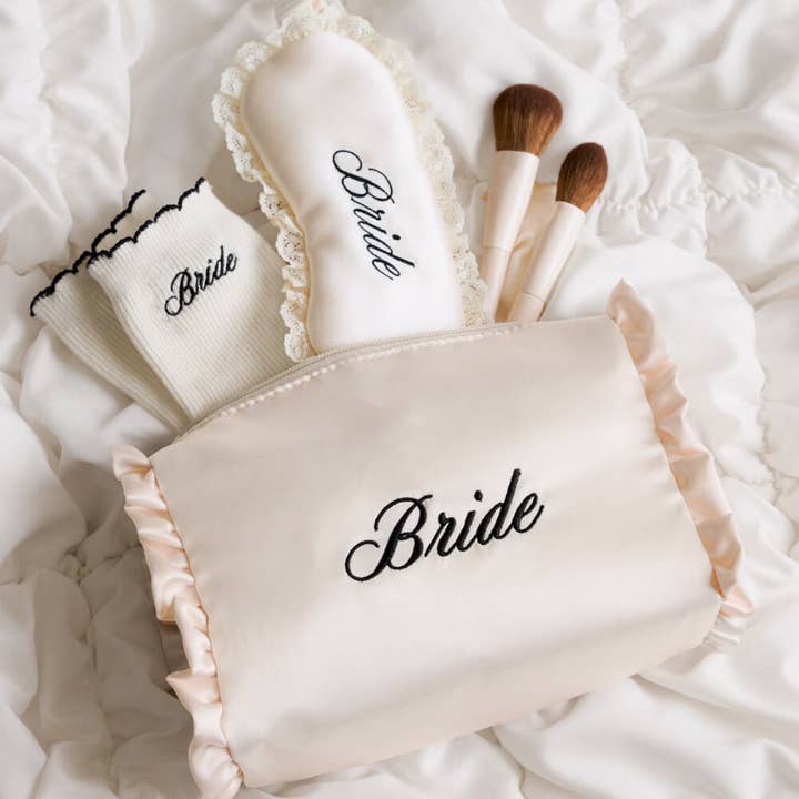 Makeup bags labeled 'Bride' with makeup brushes on a soft white background