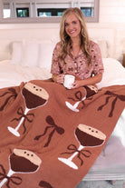 short-sleeve button-down style top with contrast piping and a chest pocket, paired with matching ruffle-trimmed shorts with an elastic waist and decorative tie, designed on a bow and martini pattern print and a brown base, crafted on a soft, lightweight stretchy fabric