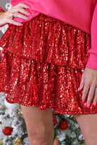 a tiered design skort with built-in shorts, an elastic waistband, and a drawstring tie on a red sequin fabric