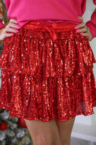 a tiered design skort with built-in shorts, an elastic waistband, and a drawstring tie on a red sequin fabric