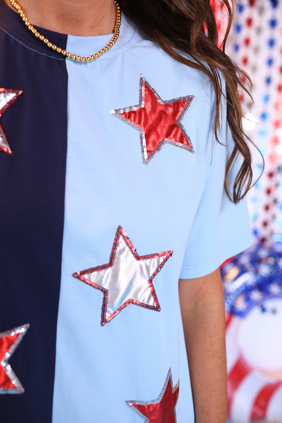 two-tone blue short-sleeved dress adorned with shimmering red and white foil stars outlined in coordinating sequins