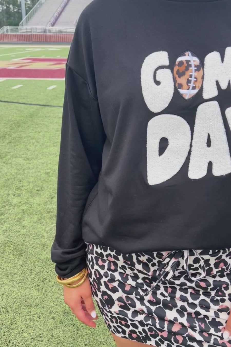 black long-sleeve sweatshirt with white chenille patch lettering reading GAME DAY in uppercase letters and a leopard football as the A in Game Day