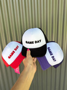 lightweight two-tone trucker hats with raised embroidered 'GAME DAY' lettering, tall foam front panel, breathable mesh back, snapback closure, and a curved bill in red, black, and purple