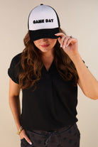 a lightweight black two-tone trucker hat with raised embroidered 'GAME DAY' lettering, tall foam front panel, breathable mesh back, snapback closure, and a curved bill