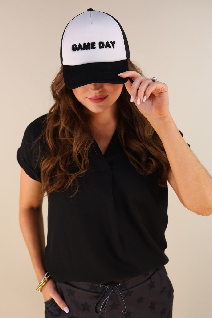a lightweight black two-tone trucker hat with raised embroidered 'GAME DAY' lettering, tall foam front panel, breathable mesh back, snapback closure, and a curved bill