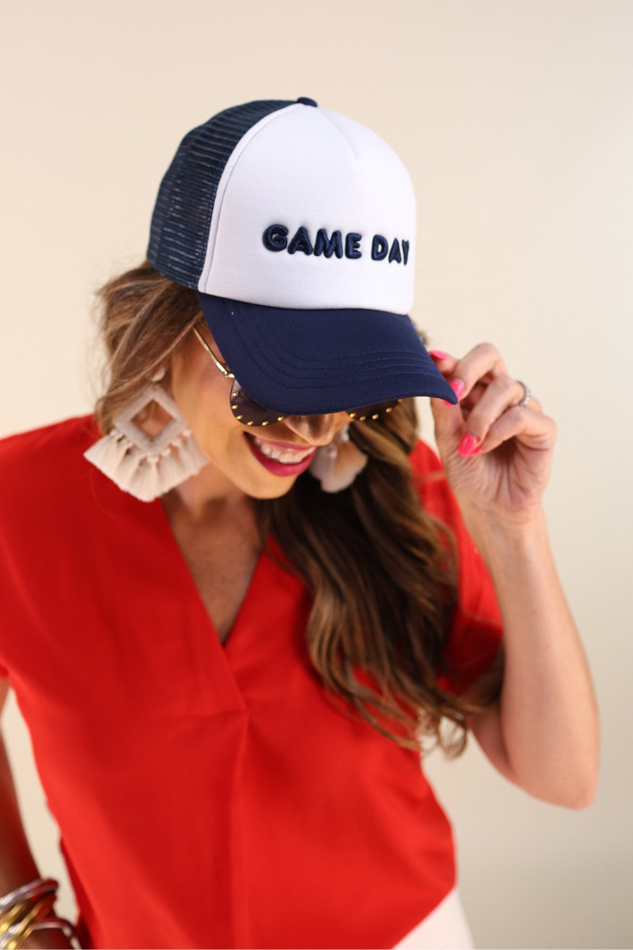 a lightweight navy two-tone trucker hat with raised embroidered 'GAME DAY' lettering, tall foam front panel, breathable mesh back, snapback closure, and a curved bill