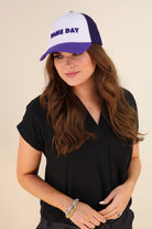 a lightweight purple two-tone trucker hat with raised embroidered 'GAME DAY' lettering, tall foam front panel, breathable mesh back, snapback closure, and a curved bill