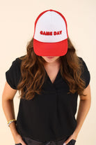 a lightweight red two-tone trucker hat with raised embroidered 'GAME DAY' lettering, tall foam front panel, breathable mesh back, snapback closure, and a curved bill
