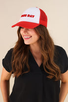 a lightweight red two-tone trucker hat with raised embroidered 'GAME DAY' lettering, tall foam front panel, breathable mesh back, snapback closure, and a curved bill