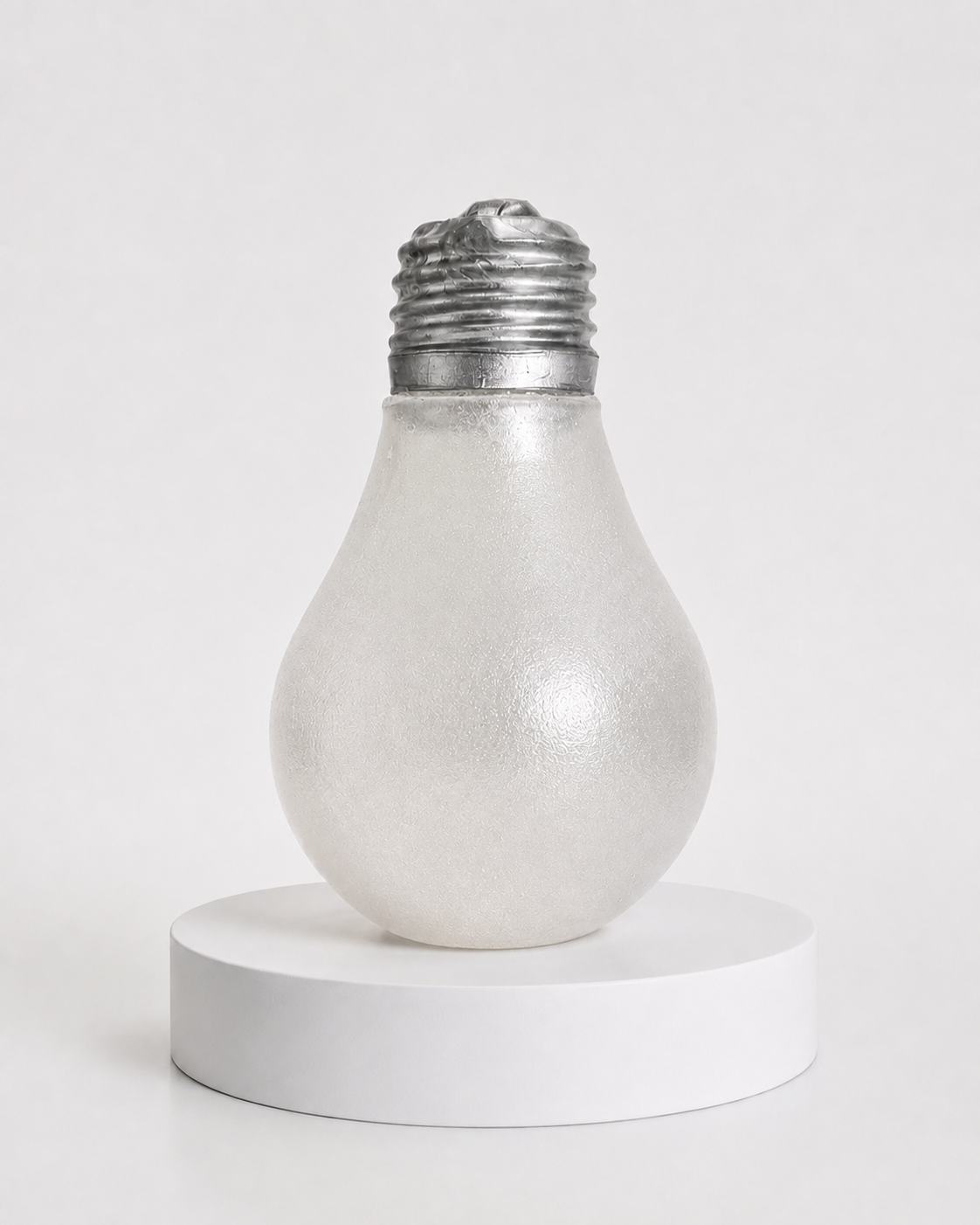 a glow-in-the-dark light bulb squishy with a frosted translucent body, metallic silver cap, soft squeezable texture, and classic bulb-inspired shape