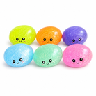 a mystery dumpling-shaped squishy fidget with assorted surprise colors, glittery finish, kawaii face, soft squeezable texture, and glow-in-the-dark feature in light blue, lime green, mint green, orange, pink, and purple