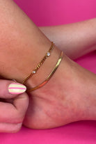 sleek herringbone chain paired with a dainty crystal-accent chain crafted from water-resistant stainless steel in gold