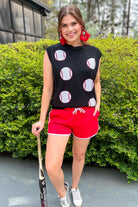 a black sleeveless sweater vest with an oversized fit, an allover textured baseball motif, and ribbed trim at the neckline, arm openings, and hem
