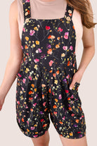 multicolor floral pattern print overall shorts on a black base made from our best-selling everyday fabric with functional button straps, cuffed hems, and side pockets