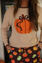 long-sleeve sweater with an oversized pumpkin, brown ribbed detailing (cuffs, neckline, and hem), and hem in brown, and a relaxed fit on a neutral base