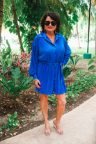 a royal blue pleated shirt dress with a classic collar, functional button front, removable waist sash, drop shoulder long sleeves, satin cuffs, back yoke seam, accordion texture, and flowy mini-length silhouette