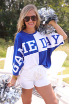 short-sleeve color block mom crop top with oversized chenille 'GAME DAY' lettering outlined in sequins, where GAME pops with a coordinating color outline to match the color block style, while DAY stands out with a crisp white outline in blue