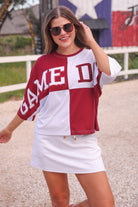 short-sleeve color block mom crop top with oversized chenille 'GAME DAY' lettering outlined in sequins, where GAME pops with a coordinating color outline to match the color block style, while DAY stands out with a crisp white outline in maroon