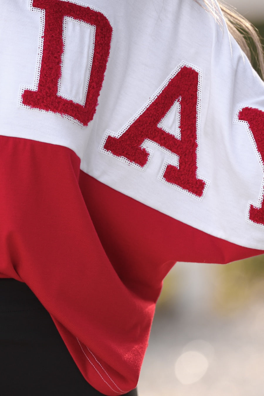 short-sleeve color block mom crop top with oversized chenille 'GAME DAY' lettering outlined in sequins, where GAME pops with a coordinating color outline to match the color block style, while DAY stands out with a crisp white outline in red