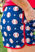 mid-rise, tie waist drawstring with gold bead accent, side pockets, & relaxed fit on a baseball, stars, & white stripe pattern on blue with red piping & gold accent bead